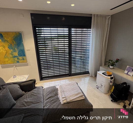 תריסים שחורים סגורים על חלון זכוכית גדול